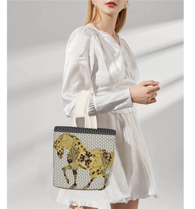 Detail of vintage canvas bucket bag with golden horse print and geometric patterns