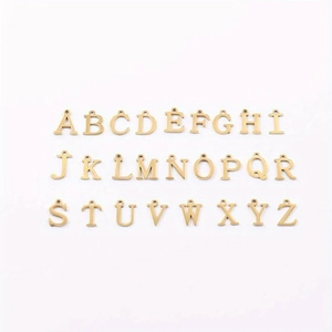 Collection of twenty-six gold letter pendants for DIY jewelry making on white background