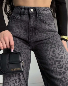 Dettaglio dei jeans a vita alta con stampa leopardata e trama denim lavata