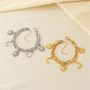 Detail of sun and moon pendants on gold and silver double-layer chain bracelets