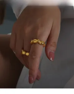 Detail of chunky irregular gold plated rings showing mirror polished bamboo joint texture
