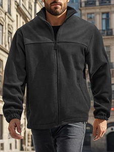 Detail of male black fleece jacket showing the high collar, zipper, and elastic cuff texture