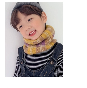 Close-up of child wearing yellow and purple checkered knitted scarf for autumn warmth