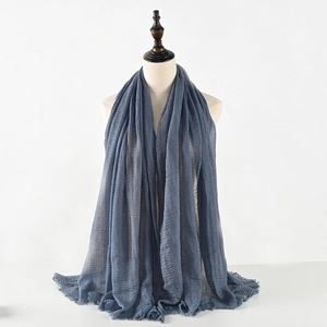 Close-up of dark blue crinkled cotton linen scarf featuring natural tassel edge details
