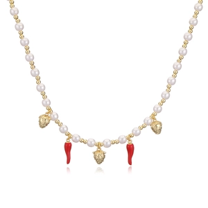 Detailed view of pearl necklace featuring gold strawberry and red chili fruit pendants
