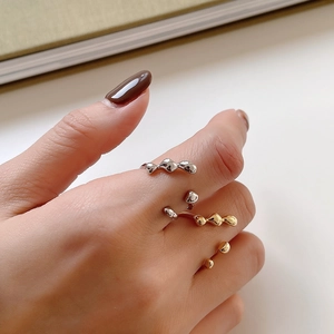 Close-up of irregular 925 silver liquid metal rings in gold and silver finishes