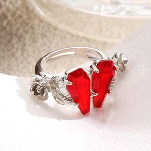 Detailed close-up of gothic silver ring with red coffin stones and rose vine patterns
