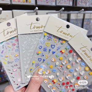 Macro detail of 5D nail art stickers with tulip and cartoon duck garden designs