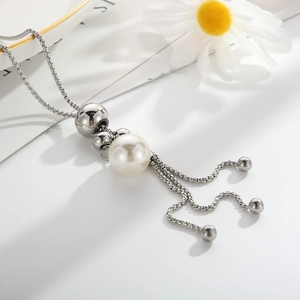 Dettaglio di una collana in argento con perla bianca e eleganti nappe in metallo