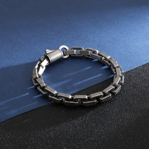 Close-up of heavy industrial titanium steel chain bracelet with a cylindrical pressure clasp