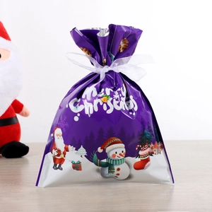 Détail du sac cadeau de Noël violet avec motifs du Père Noël et ruban de serrage blanc