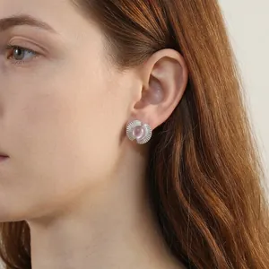Pink cat eye stone fan shaped stud earrings with silver textured frame on female ear