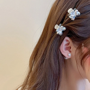 Détail de la pince à cheveux ours argenté avec accents bleus et perles sur modèle