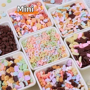 Assorted colorful resin flower and star charms for DIY crafts in white divider boxes