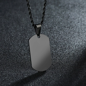 Macro view of a smooth black metal military tag pendant with a matching twisted rope chain