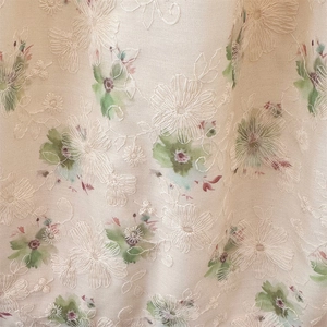Close-up of white canvas fabric with 3D floral embroidery and colorful watercolor prints
