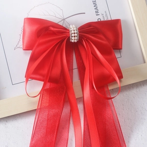 Detail of red Hanfu bow hair clip with faux pearls, rhinestones and long tassels