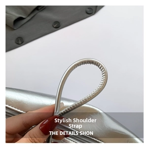 Close-up of slim silver cylindrical shoulder strap with high-quality leather grain