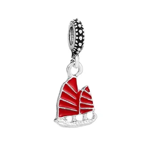 Detailed close-up of a silver sailboat charm with vibrant red enamel and S925 engraving