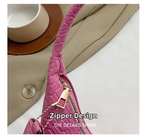 Detail of premium golden metal zipper and woven texture on a pink handbag