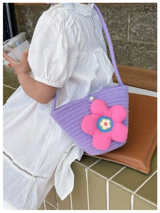 Detail der lila geflochtenen Kinder-Strohtasche mit großer rosa 3D-Dekoblume