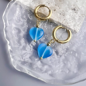 Detail of 18K gold stainless steel heart earrings with blue cat eye stone pendants