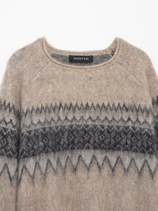 Detail shot of vintage geometric jacquard pattern on a light brown knit sweater
