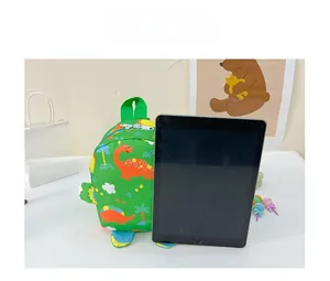 Size comparison of green dinosaur toddler backpack next to a 10 inch tablet