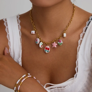 Golden pearl chain necklace with painted ceramic tulip and heart charms worn by model