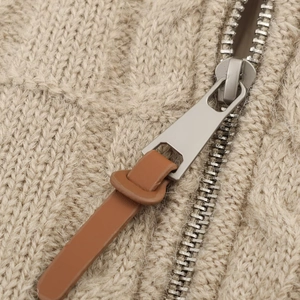 Beige chunky cable knit vest with metallic zipper and brown leather puller detail