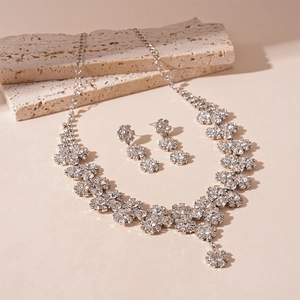 Macro detail of silver sunflower necklace and earrings set with shimmering crystals