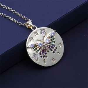Close-up of golden necklace with colorful crystal butterfly and star charms on pendant