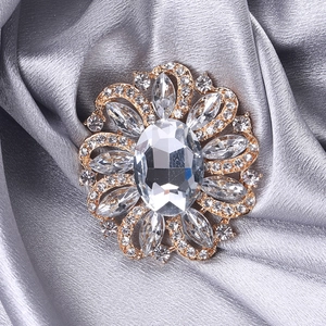 Detailed view of flower brooch with oval crystal on elegant silver satin background