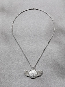 Détail du collier chaîne torsadée argentée avec pendentif turquoise blanche ailé