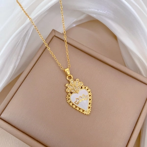 Close-up of gold crown heart pendant with white inlay and cubic zirconia on silk