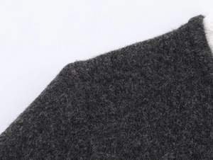 Macro shot of dark grey knit fabric texture showing soft fibrous details and material quality