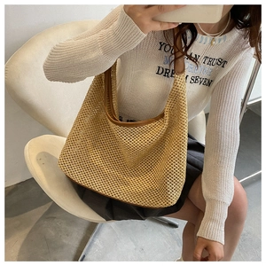 Detail of woven mesh texture on beige shoulder bag with leather trim and soft structure
