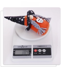Weight display of Halloween gnome doll with pointed hat and skull charm on digital scale