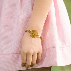 Elegant gold-tone Hamsa hand double-layer bracelet worn by a model on a wrist
