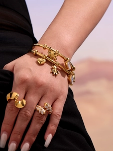 Detail of 18k gold plated stainless steel bracelets and rings on a model wrist