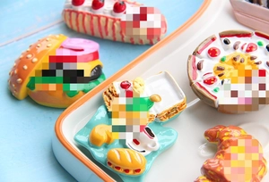 Macro view of realistic resin food magnets including burgers, pizza, and croissants