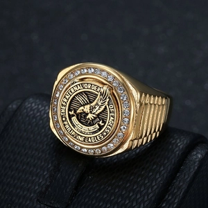 Macro detail of gold-plated eagle seal ring with white zircons on a leather base