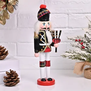 Detail of wooden nutcracker soldier in Scottish uniform holding a pipe organ on white wall