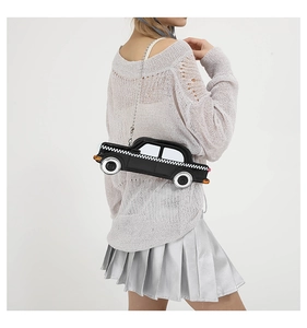 Detail view of a creative taxi-shaped crossbody bag with checkerboard pattern and chain