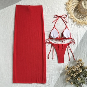 Flat lay of a red three-piece knit bikini set including a mesh skirt and halter top