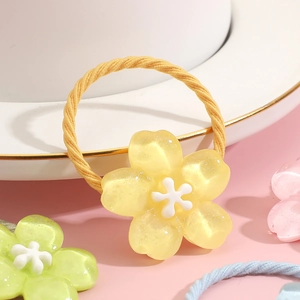Elastic yellow flower hair tie for girls featuring a glittery resin petal design
