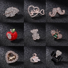Detailed close-up of nine elegant alloy brooches featuring swan and apple designs