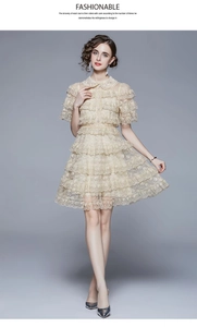 Detail of elegant apricot lace dress featuring tiered ruffle layers and sequin accents