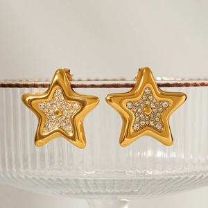 Gold star stud earrings with pavé crystals on a glass edge for a luxury jewelry look