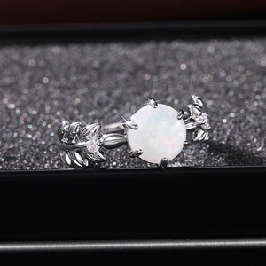 Vista macro di un anello a foglia d'argento con opale bianco e dettagli in zirconi cubici